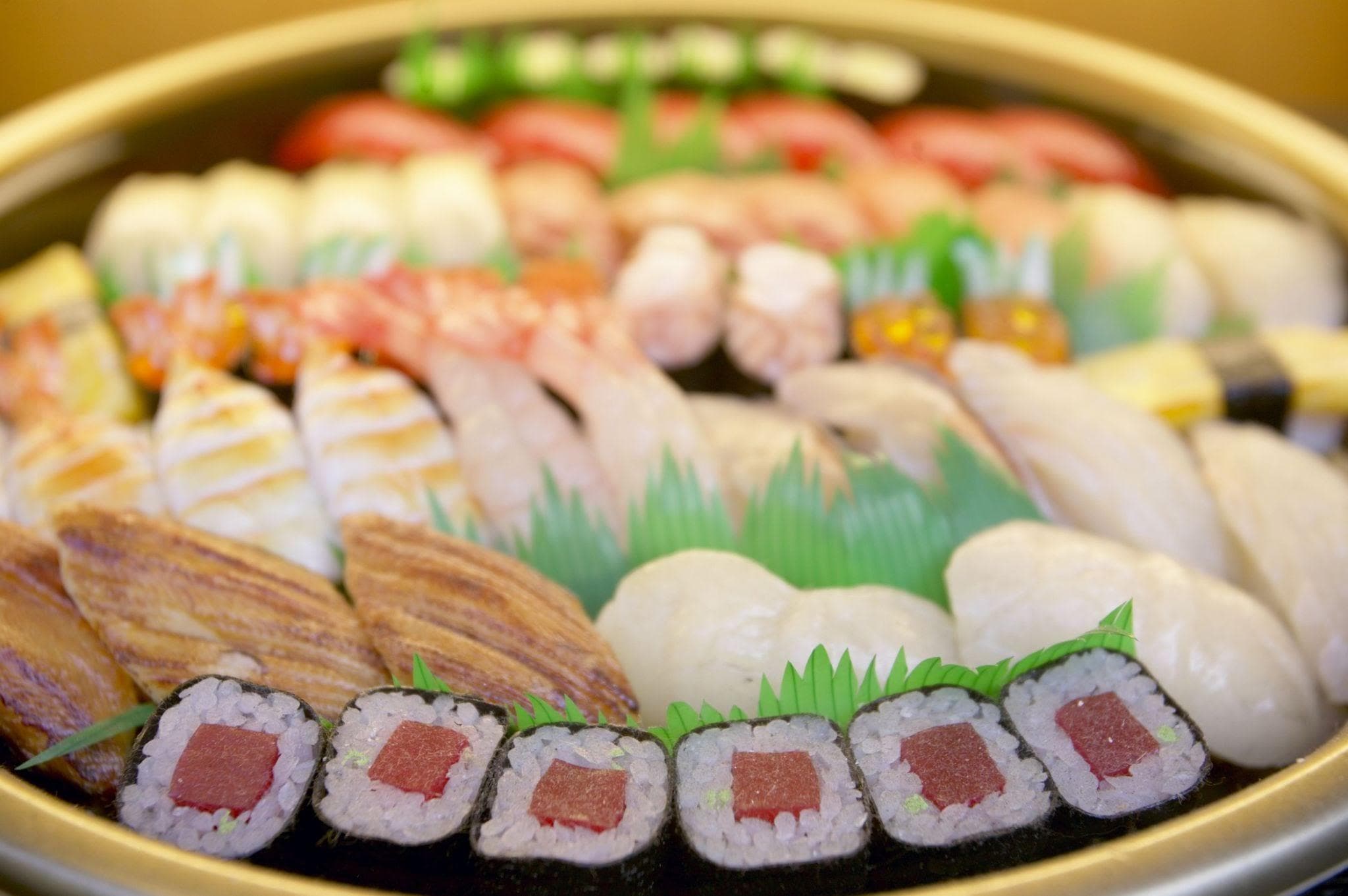 Plat de sushi avec sauce rouge sur planche en bois